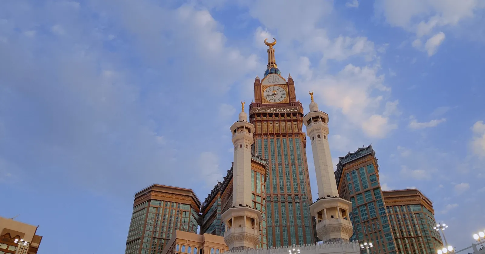 Bulutlu gökyüzü altında Mekke'deki Abraj Al Bait saat kulesi